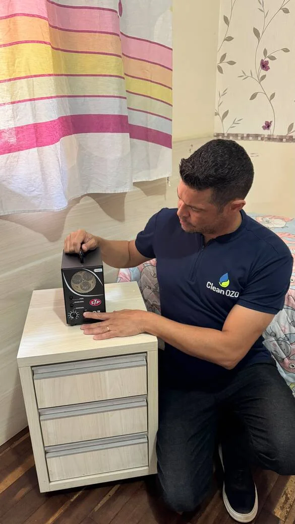 Técnico da Clean Ozo posicionando gerador de ozônio em quarto para sanitização
