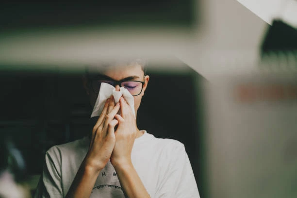 Pessoa com alergia respiratória usando lenço